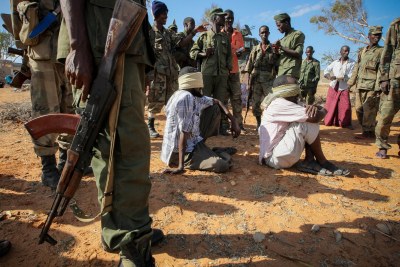 Alleged suspects of the extremist group Al-Shabaab are guarded by soldiers of the Somali National Army in Kismayo, Somalia (file photo).